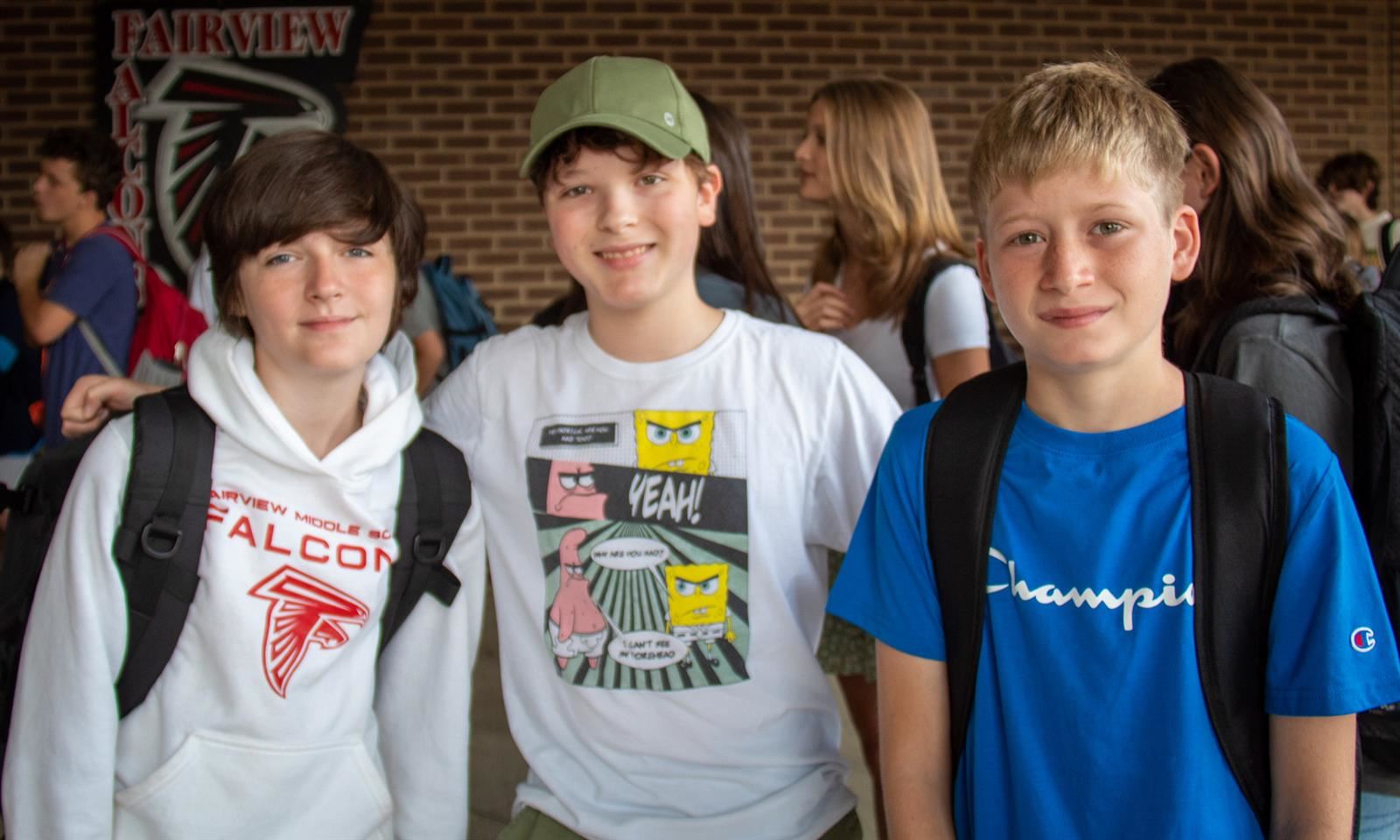 Three students smile